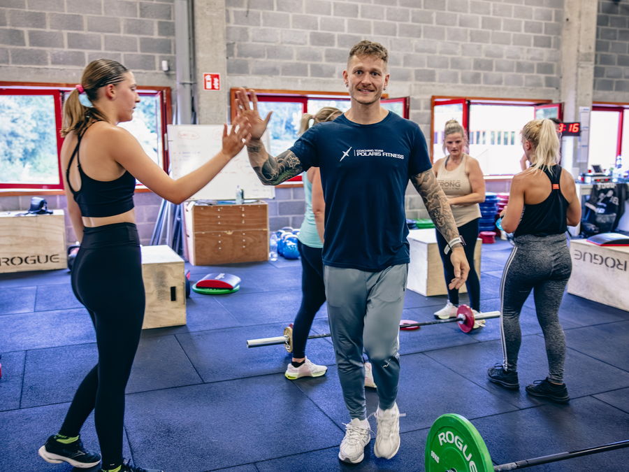 Un coach de Polaris Fitness félicite une membre pendant un cours